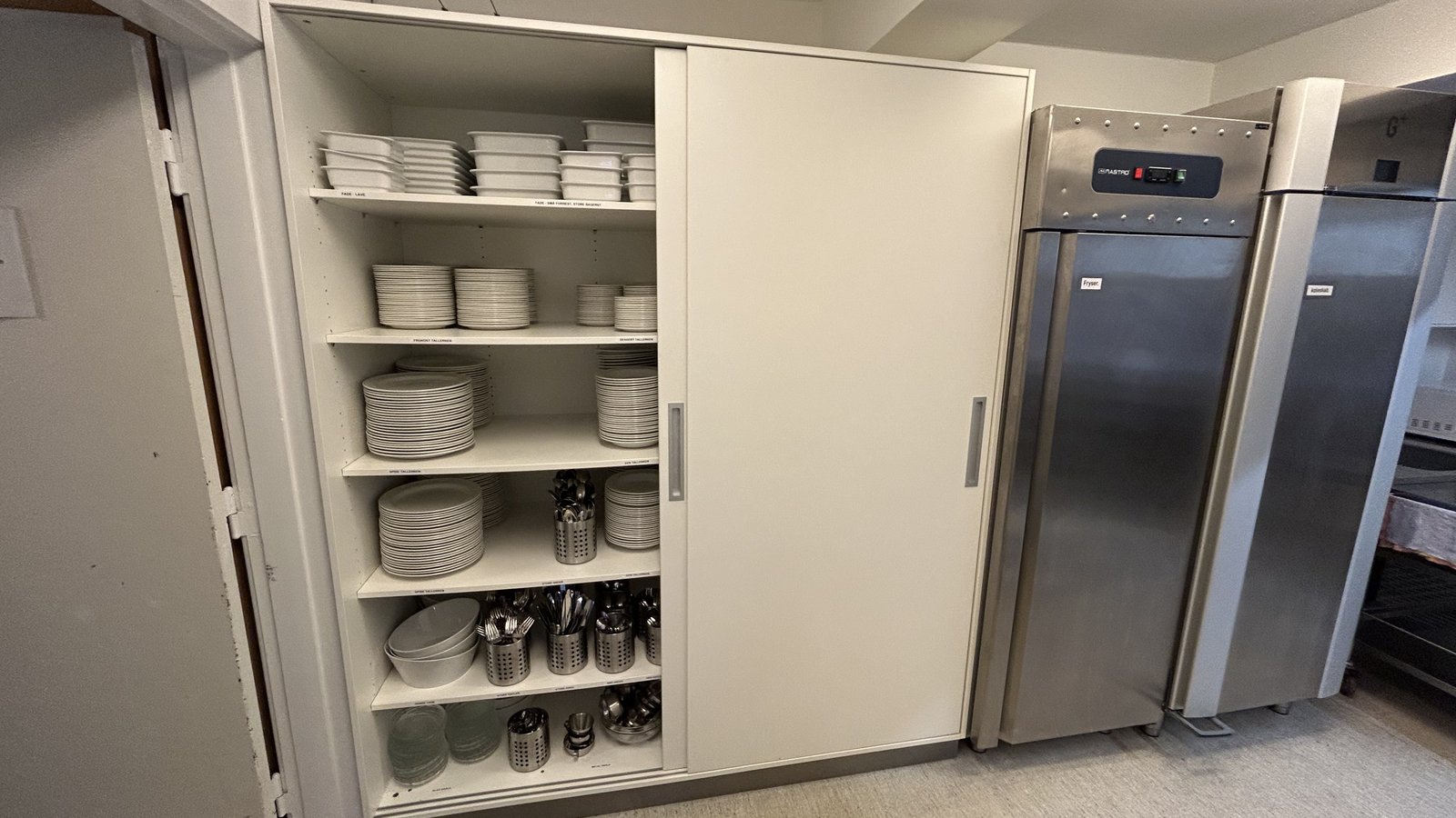 Service og tallerkener i køkkenskab